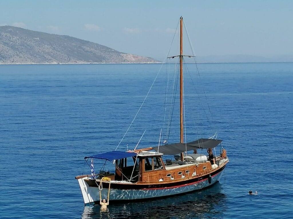 Thassos boat cruise Odyssia anchored in blue Aegean waters with happy customers